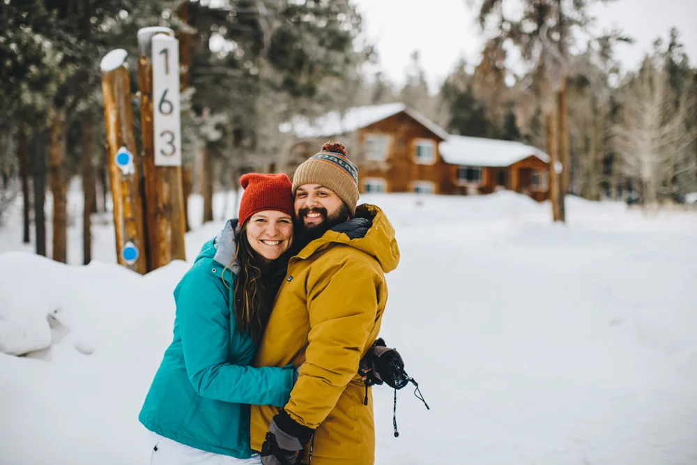 Reaghen and Jackson outside a snowy Colorado cabin